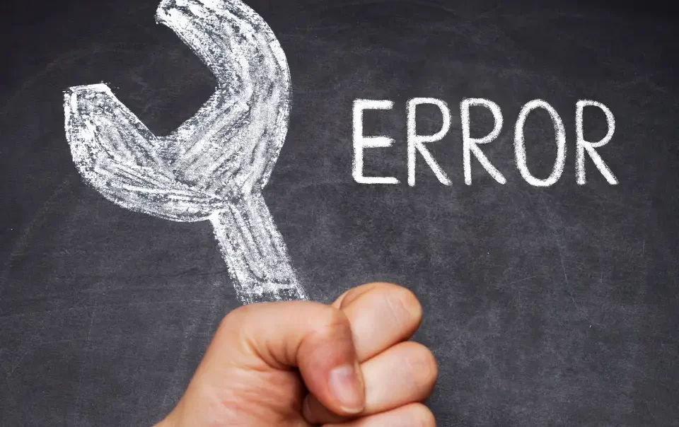 Mano sosteniendo real sosteniendo una Llave fija dibujada con tiza y al lado escrito ERROR